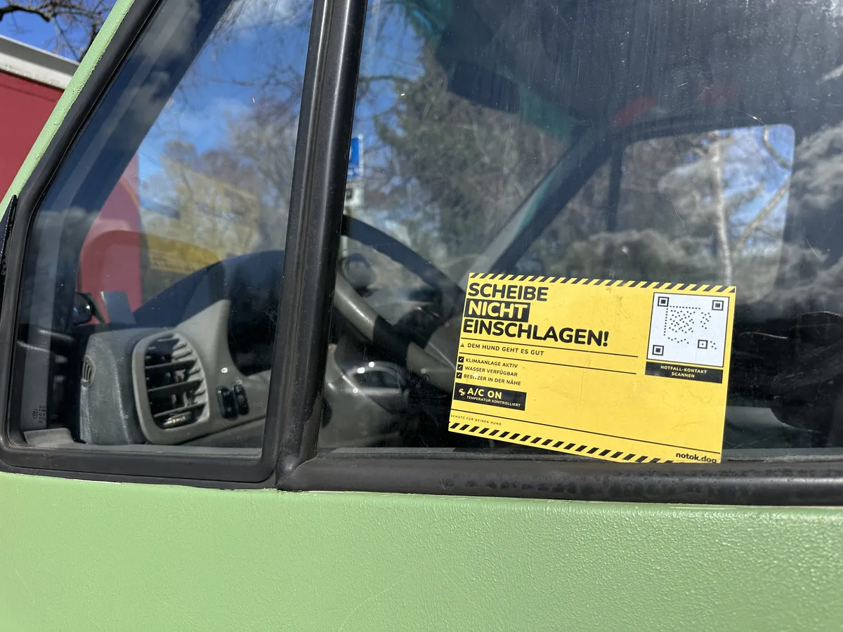 Gelber 'Scheibe nicht einschlagen' Sticker am grünen Van